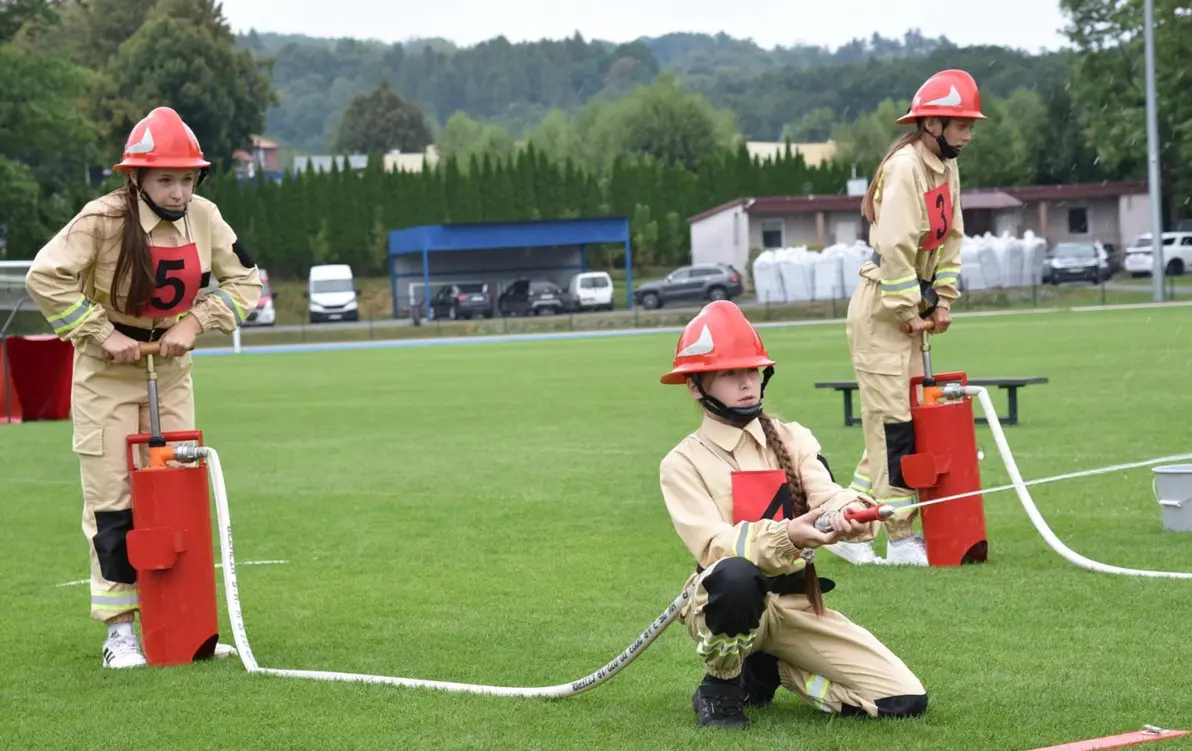 Grupa młodzieżowa z&nbsp;OSP z&nbsp;wężem strażackim podczas zawod&oacute;w